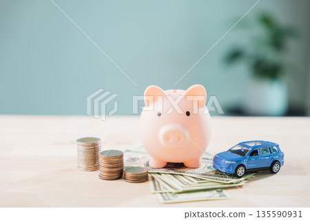 Piggy bank with car helps save money for auto insurance and fuel cost, refinance loan or finance drive and gas for transportation needs monthly budget planning with savings Piggy bank with car helps save money for auto insurance and fuel cost, refinance loan or finance drive and gas for transportation needs monthly budget planning with savings 135590931