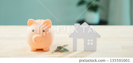 Real estate investment money piggy bank saving home house property insurance, pink piggy bank beside white house model with keys represents plan to save for future mortgage Real estate investment money piggy bank saving home house property insurance, pink piggy bank beside white house model with keys represents plan to save for future mortgage 135591001