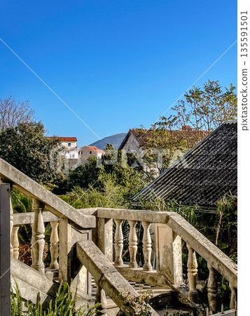 sunshine over aged terrace, historic stone balcony reveals tranquil village and mountain views sunshine over aged terrace, historic stone balcony reveals tranquil village and mountain views 135591501
