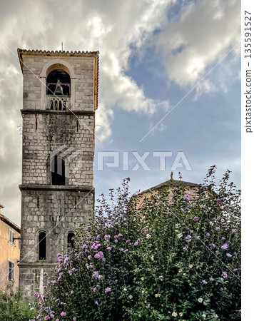 The Historic Bell Tower is Beautifully Surrounded by Vibrant and Colorful Flowers Blooming 135591527