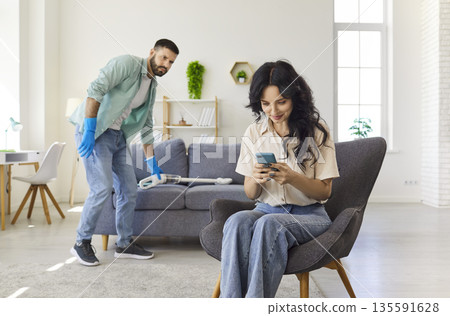 Couple at home during living room cleaning, jealous man suspecting deception Couple at home during living room cleaning, jealous man suspecting deception 135591628