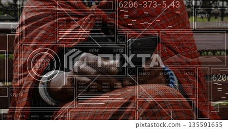 Holding smartphone man analyzing data overlays on park bench, wearing shirt, jeans, wrist bracelets 135591655
