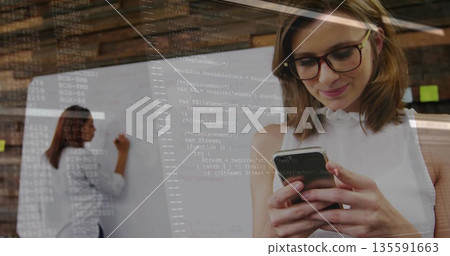 Working woman in white blouse writing on whiteboard in office, viewing code overlay on smartphone Working woman in white blouse writing on whiteboard in office, viewing code overlay on smartphone 135591663