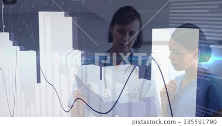 Medical team reviewing data on clipboard with stethoscope in clinic with bar charts, line graphs 135591790