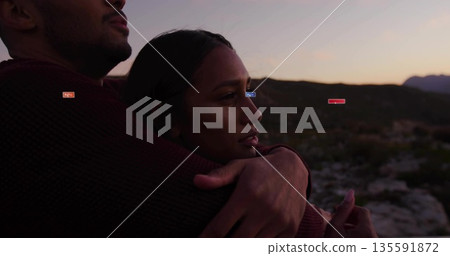 Embracing couple overlooking rocky valley at dusk, with burgundy knit sweater and brownish knit top Embracing couple overlooking rocky valley at dusk, with burgundy knit sweater and brownish knit top 135591872