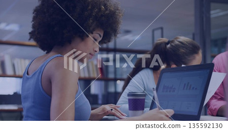 Typing woman wearing blue ribbed tank top using laptop in modern office, with notebooks, copy space 135592130