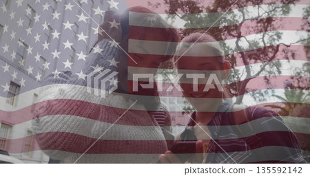 Teenage girls wearing red beanie standing on city sidewalk viewing smartphone, with flag overlay Teenage girls wearing red beanie standing on city sidewalk viewing smartphone, with flag overlay 135592142