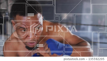 Throwing punch shirtless male boxer training inside gym boxing ring with ropes and blue hand wraps Throwing punch shirtless male boxer training inside gym boxing ring with ropes and blue hand wraps 135592205