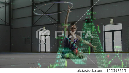 Kneeling gymnast in dark blue leotard spinning hoop in sports hall with floating digital overlays 135592215