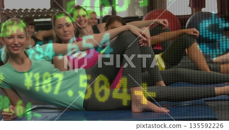 Participants performing side plank in workout clothes on blue mats in fitness studio, numeric data 135592226