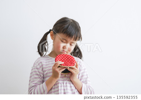 Child holding a clasp wallet (money/pocket money) 135592355