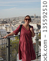 Woman Enjoying Paris Cityscape from Rooftop Balcony 135592510