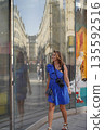 Woman in Blue Dress Walking by Reflective Storefront 135592516