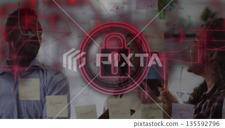 Highlighting security lock icon on glass board with sticky notes during team planning in office Highlighting security lock icon on glass board with sticky notes during team planning in office 135592796