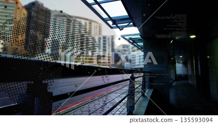 Speeding commuter train blurring across modern urban rail platform, with perforated safety screen Speeding commuter train blurring across modern urban rail platform, with perforated safety screen 135593094