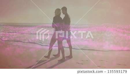 White female and Hispanic male walking along sandy shore at water edge, with sunglasses, footprints White female and Hispanic male walking along sandy shore at water edge, with sunglasses, footprints 135593179