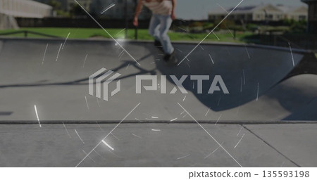 Riding skateboarder carving along bowl lip at skatepark bowl, with skateboard and suburban houses 135593198