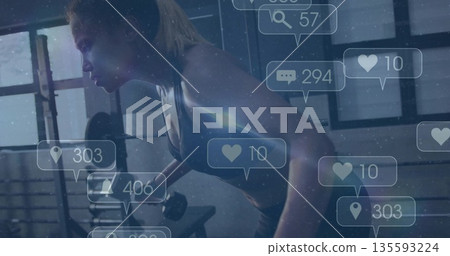 Woman wearing sportswear performing bent-over dumbbell row in gym by bench, with social media icons 135593224