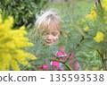 Child Enjoying Nature Amidst Yellow Flowers 135593538