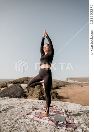 Woman Practicing Yoga on a Mountaintop Woman Practicing Yoga on a Mountaintop 135593873