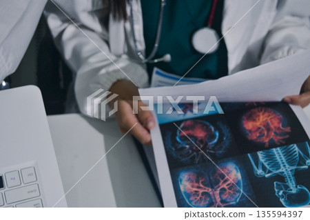 Doctor Explaining X-Ray Results to a Patient Using a Digital Device 135594397