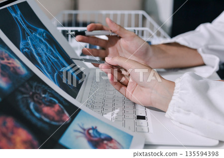 Doctor Explaining X-Ray Results to a Patient Using a Digital Device 135594398