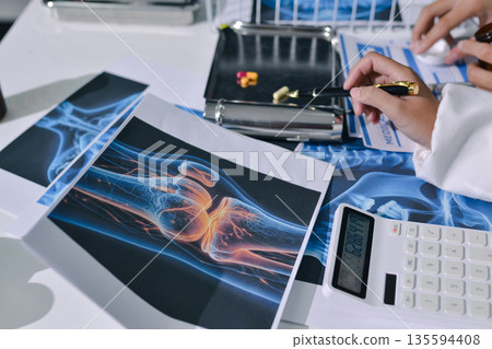 Doctor Explaining X-Ray Results to a Patient Using a Digital Device 135594408