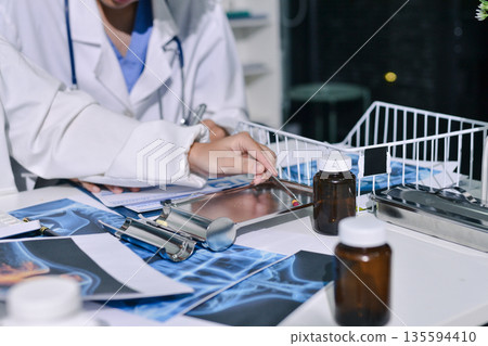 Doctor Explaining X-Ray Results to a Patient Using a Digital Device Doctor Explaining X-Ray Results to a Patient Using a Digital Device 135594410