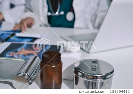 Doctor Explaining X-Ray Results to a Patient Using a Digital Device 135594412