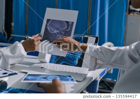 Doctor Explaining X-Ray Results to a Patient Using a Digital Device 135594417