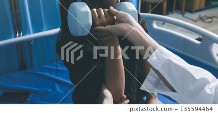 Unrecognizable uses blue hand weight during physical therapy session Unrecognizable uses blue hand weight during physical therapy session 135594464