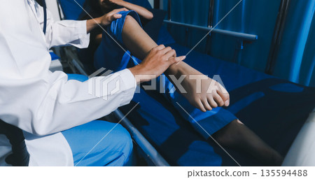 Asian male doctor examining foot of female patient sitting on bed in hospital room. Performing medical checkup. Diagnosing injury. Providing healthcare. Podiatry. Physical therapy. And rehabilitation Asian male doctor examining foot of female patient sitting on bed in hospital room. Performing medical checkup. Diagnosing injury. Providing healthcare. Podiatry. Physical therapy. And rehabilitation 135594488