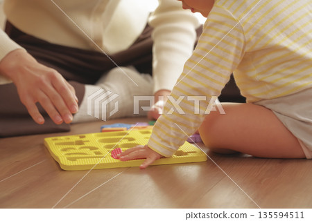 Mother and child having fun playing with toys for toddlers Mother and child having fun playing with toys for toddlers 135594511