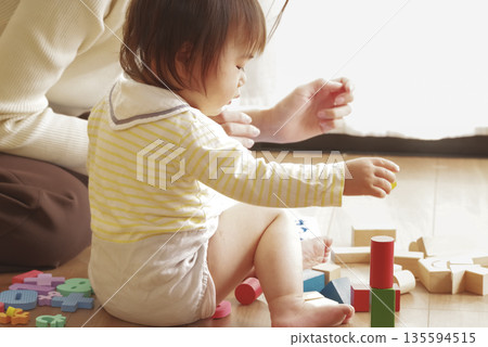 母親和孩子一起玩幼兒玩具,其樂融融。 母親和孩子一起玩幼兒玩具,其樂融融。 135594515