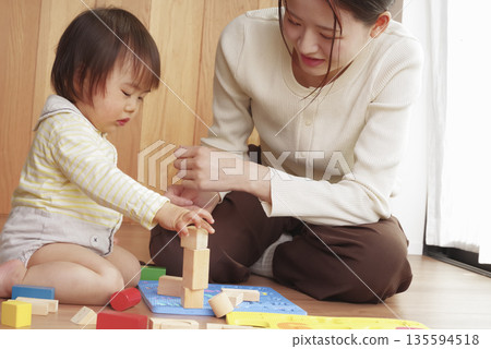 母親和孩子一起玩幼兒玩具,其樂融融。 母親和孩子一起玩幼兒玩具,其樂融融。 135594518