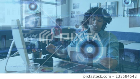 Gesturing African American male interacting with laptop and digital overlays in modern office Gesturing African American male interacting with laptop and digital overlays in modern office 135594548