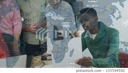 Analyzing global data man in green sweater holding chart at meeting table, with laptops, copy space 135594592