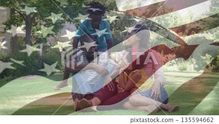Sitting family of four playing on sunny suburban backyard lawn, with casual clothing and lush grass Sitting family of four playing on sunny suburban backyard lawn, with casual clothing and lush grass 135594662