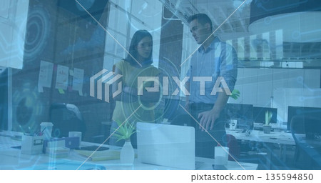 Leaning co-workers in office attire examining data graphics in office, with laptop and sticky notes Leaning co-workers in office attire examining data graphics in office, with laptop and sticky notes 135594850