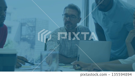 Manager in checkered shirt and team discussing documents in meeting room near window, with laptop 135594894