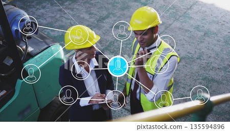 Site workers in hard hats, vests chatting in yard with forklift radio and network icons 135594896