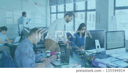 Collaborating five business professionals reviewing data on monitors in open office, with laptops 135594914
