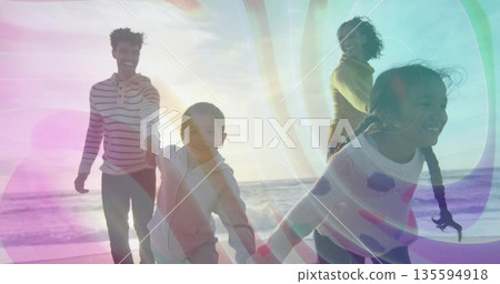 Running family wearing striped shirt, sweater, zip-up hoodie, leggings on sunset beach, with light 135594918