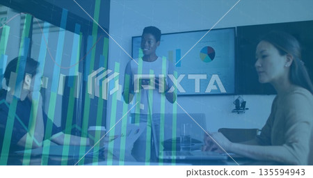 Leading business speaker showing data graphs in conference room, with tablet, laptops, pie chart 135594943