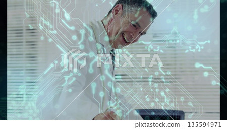 Smiling professional leaning over desk working on laptop in office, with circuit-pattern overlay Smiling professional leaning over desk working on laptop in office, with circuit-pattern overlay 135594971