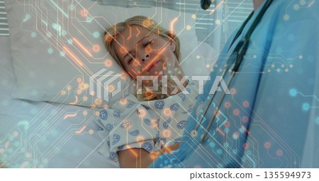 Listening doctor assessing patient pulse at hospital bedside, with stethoscope and patterned gown 135594973