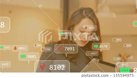 Studying professional woman scanning tablet screen in modern cafe, with digital notification icons 135594975