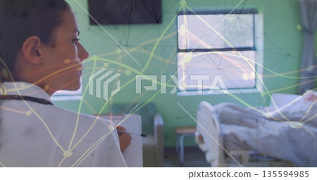 Holding clipboard and pen with stethoscope, clinician checking bed in hospital room, with monitor 135594985