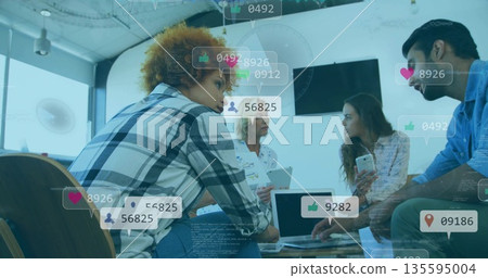 Collaborating four professionals analyzing social media metrics in office using laptop smartphone 135595004