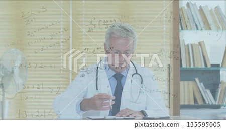 Writing male doctor taking patient chart notes at medical office desk, with stethoscope and fan Writing male doctor taking patient chart notes at medical office desk, with stethoscope and fan 135595005